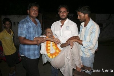 Brij Bihari Pandey, 108, is assisted by relatives following his release from the Gorakhpur district prison in Gorakhpur on Friday.