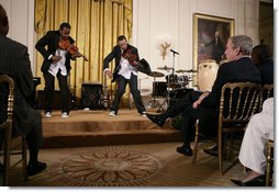 President George W. Bush and guests watch violinists Tourie and Damien Escobar of Nuttin But Stringz, as they perform Friday, June 22, 2007 in the East Room of the White House, in celebration of Black Music Month. White House photo by Eric Draper