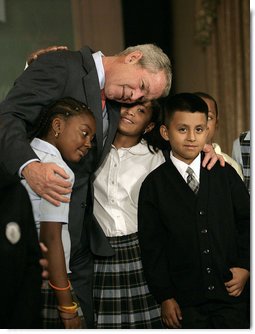 President George W. Bush hugs students from New York Public School 76 as he makes a statement to the press about No Child Left Behind Wednesday, Sept. 26, 2007, in New York. "Last week the school system here in New York City received the Broad Prize for Urban Education. This is one of the most prestigious education prizes in the country," said the President. "The award is given every year to large urban school districts that have shown the greatest overall performance and improvement in student achievement, while narrowing the achievement gap amongst poor and minority students." White House photo by Eric Draper