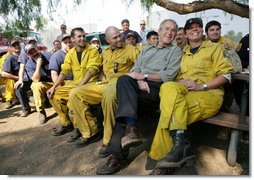 President George W. Bush visits a base camp Thursday, Oct. 25, 2007, for First Responders battling the Southern California wildfires. "I'm telling you, there's a lot of folks that live up in these hills that have their houses because of you," the President told the fire fighters. ". They're not in a position to thank you -- but we are. And so we thank you for helping save lives and save property." White House photo by Eric Draper