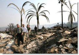 President George W. Bush is followed by Congressman Brian Bilbray as he tours a fire-ravaged neighborhood in Rancho Bernardo, California Thursday, Oct. 25, 2007. The President spent the day touring the Southern California region that has been victim to Santa Ana wind-fed wildfires since Sunday. White House photo by Eric Draper