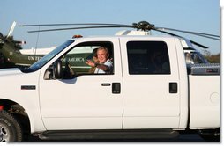 President George W. Bush waves as he drives German Chancellor Angela Merkel, Mrs. Laura Bush and Merkels husband, Dr. Joachim Sauer, following the Merkels arrival to the Bush ranch in Crawford, Texas, Friday, Nov. 9, 2007. White House photo by Shealah Craighead