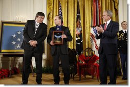 President George W. Bush applauds after presenting the Medal of Honor posthumously to family members of U.S. Army Master Sgt. Woodrow Wilson Keeble, Monday, March 3, 2008 in the East Room of the White House, in honor of Master Sgt. Keebles gallantry during his service in the Korean War. Kurt Bluedog, left, Keebles great nephew, and Russ Hawkins, a step-son, accepted the award honoring Keeble, the first full-blooded Sioux Indian to receive the Medal of Honor. White House photo by Eric Draper