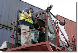 President George W. Bush sits inside the cab of a stacker as its operator, Frederick Bishop, looks on Tuesday, March 18, 2008, during a tour of Coastal Maritime Stevedoring, LLC at the Blount Island Marine Terminal in Jacksonville, Fla. White House photo by Chris Greenberg