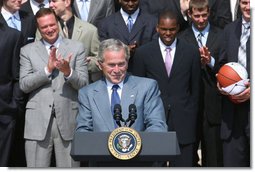 President George W. Bush acknowledges the applause as he greets the University of Kansas Jayhawks Tuesday, June 3, 2008, to the Rose Garden. President Bush told the 2008 NCAA Men's Basketball champs, "I want to congratulate this team. You brought new glory to one of our nation's most storied basketball programs, and you gave your fans all across America one more reason to chant: Rock Chalk, Jayhawk!"  White House photo by Joyce N. Boghosian