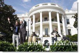 President George W. Bush is joined by Colombian musician Andres Cabas as they wave to invited guests, following Cabas and his band's performance Thursday, Oct. 9, 2008 on the South Lawn of the White House, during the celebration of Hispanic Heritage Month.  White House photo by Joyce N. Boghosian