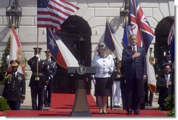 President George W. Bush stands with his hand over his heart during the playing the Americas national anthem during the Arrival Ceremony for Her Majesty Queen Elizabeth II and His Royal Highness The Prince Philip Duke of Edinburgh Monday, May 7, 2007, on the South Lawn. White House photo by Lynden Steele