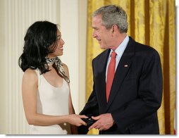 President George W. Bush congratulates Angela An of Washington, D.C., on presenting her the Presidents Volunteer Service Award Thursday, May 10, 2007, in the East Room of the White House, in celebration of Asian Pacific American Heritage Month.  White House photo by Eric Draper