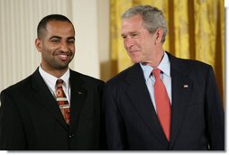 President George W. Bush speaks with award recipient Adeel Khan of Springfield, Va., student body president at Virginia Tech, on stage in the East Room of the White House, where Khan received the Presidents Volunteer Service Award Thursday, May 10, 2007, in celebration of Asian Pacific American Heritage Month.  White House photo by Eric Draper