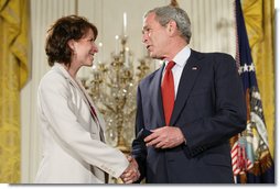 President George W. Bush congratulates military spouse Shannon Maxwell of Jacksonville, N.C., as Maxwell is presented with the Presidents Volunteer Service Award Thursday, May 10, 2007, in the East Room of the White House during a celebration of Military Spouse Day. White House photo by Eric Draper