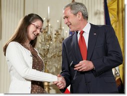 President George W. Bush congratulates military spouse Linda Port of Langley Air Force Base, Va., as she is presented with the Presidents Volunteer Service Award Thursday, May 10, 2007, in the East Room of the White House during a celebration of Military Spouse Day. White House photo by Eric Draper